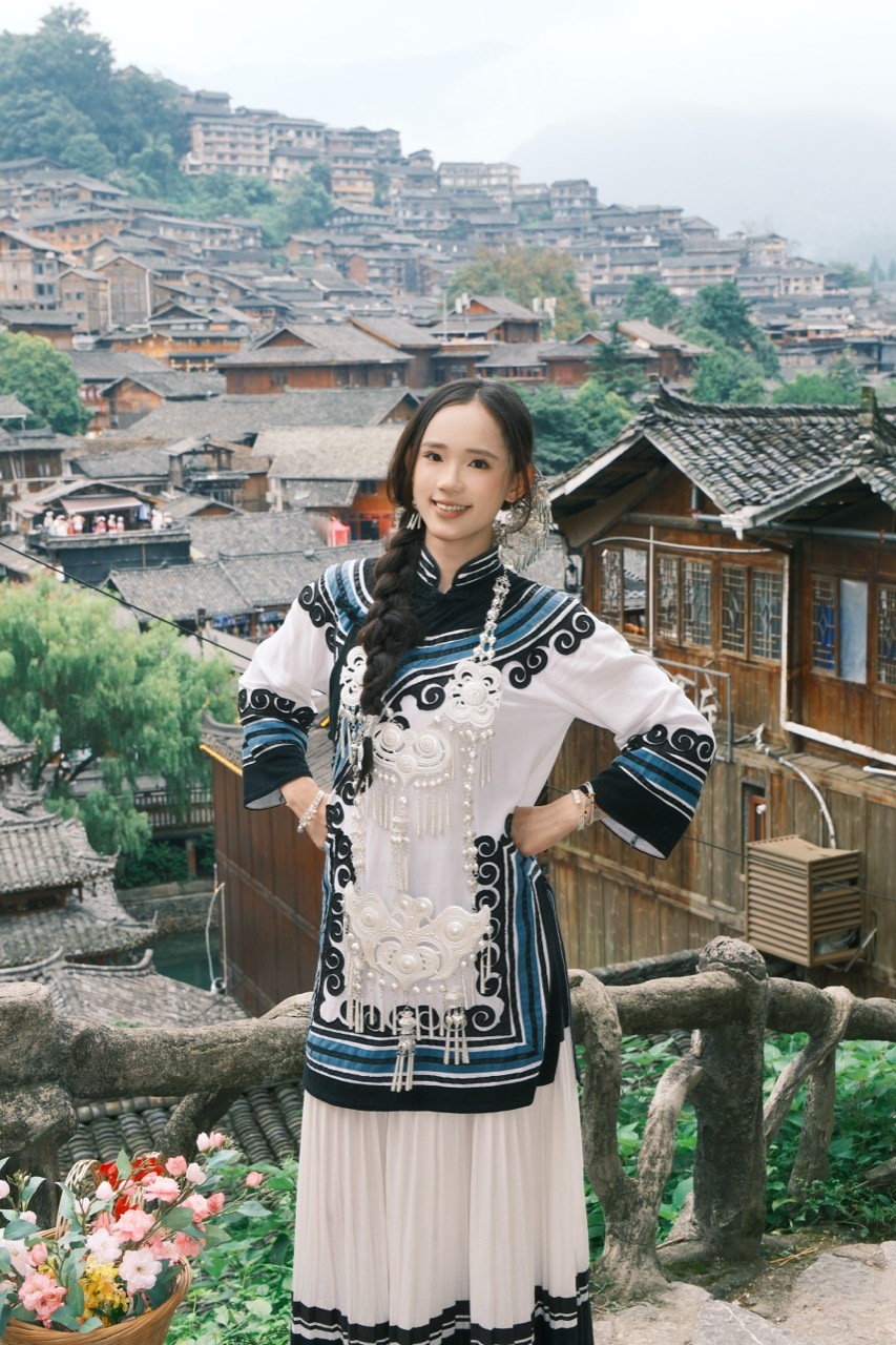 Chenshuo in front of a hillside village