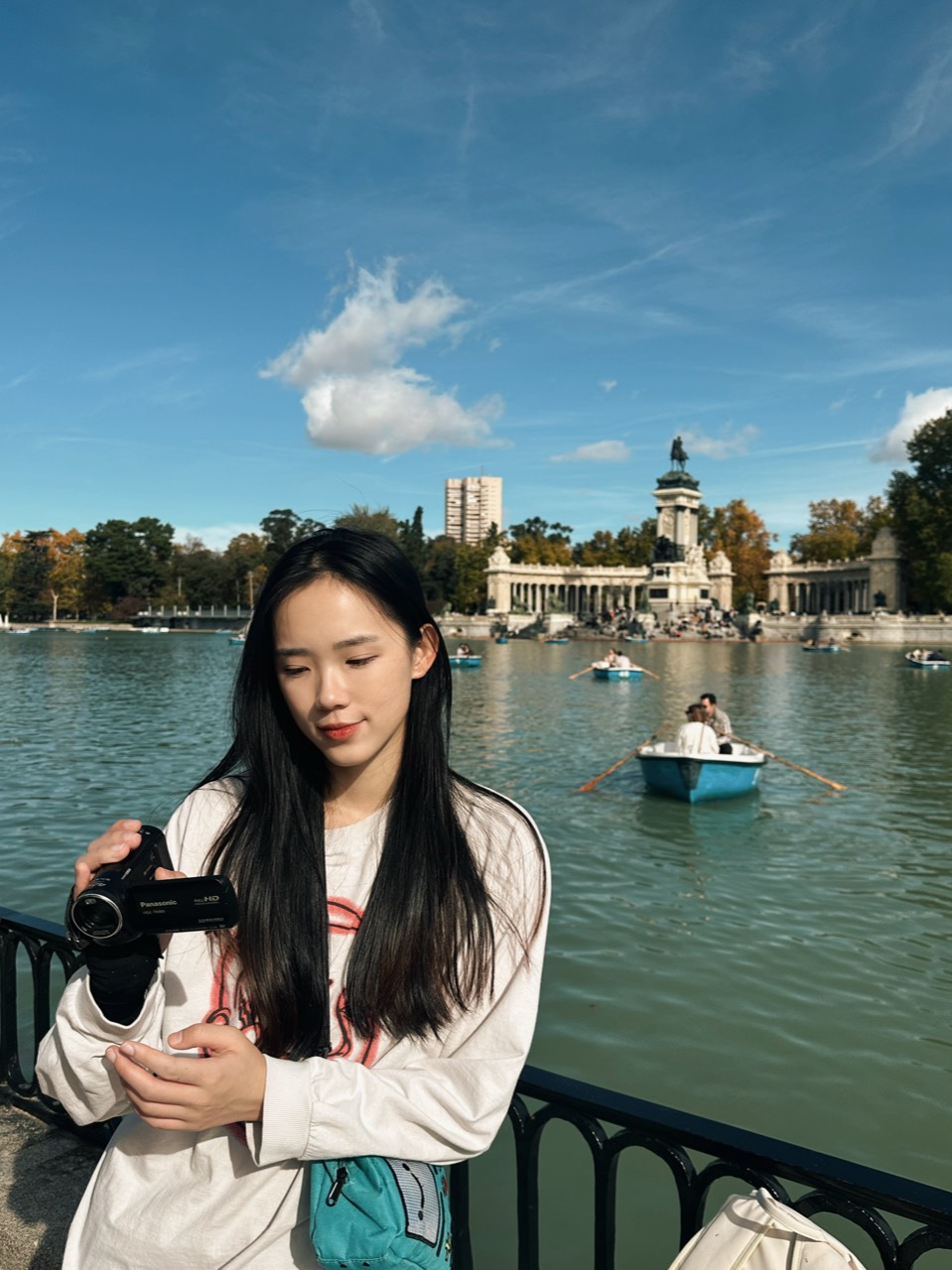 Chenshuo holding a camera beside a lake